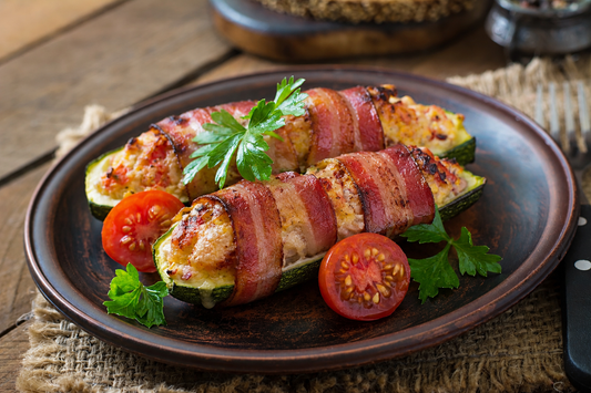 Bacon-wrapped stuffed zucchini boats with a golden cheesy filling, served on a rustic plate with parsley and cherry tomatoes.