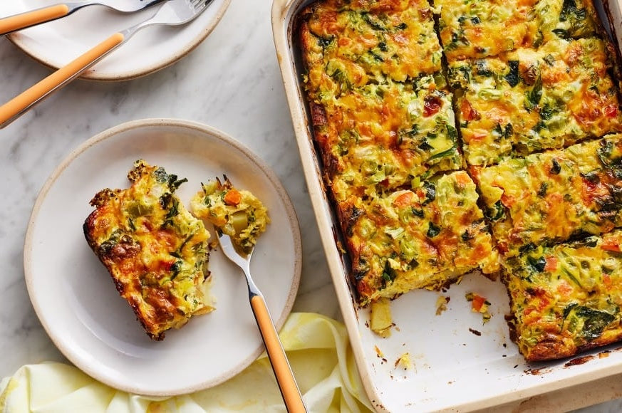 Christmas Casserole in a platter with a plate and a slice of casserole in it