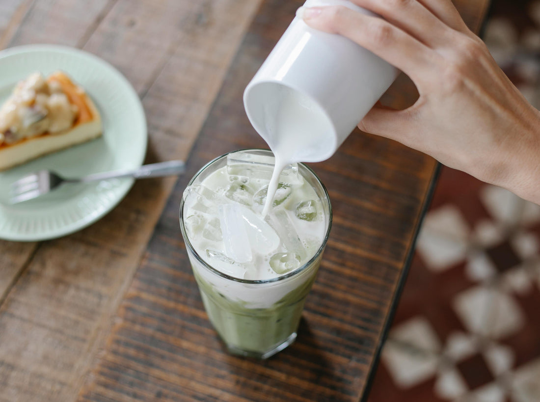 hand pouring oat milk in glass and enjoying health benefits
